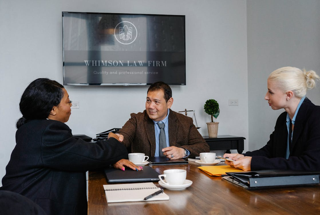 multiethnic colleagues shaking hands in law office