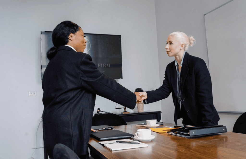 A law firm's leadership team welcoming a new hire in a modern office setting